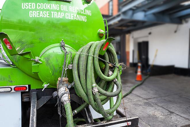 a professional technician pumping a restaurant's grease trap in Baldwin Place NY